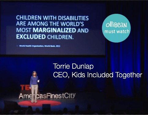 A photograph of a woman wearing a purple shirt and khaki pants giving a speech on stage. TED in bold red letters , and "America's Finest City" is partially visible behind her. On a large screen behind her " Children with disabilities are among the world's most marginalized and excluded children." To the right there is a turqoise circle with white font "Ollibean Must Watch"/ Also in white font " Torrie Dunlap, CEO, Kids Included Together